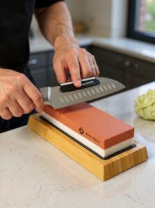 Sharpening knife with whetstone in kitchen
