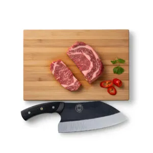 Raw steak with knife on cutting board