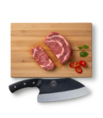 Raw steak with knife on cutting board