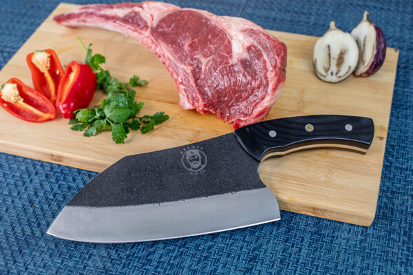 Steak, peppers, herbs, and knife on cutting board.