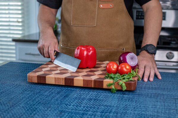 Chef slicing vegetables on cutting board.