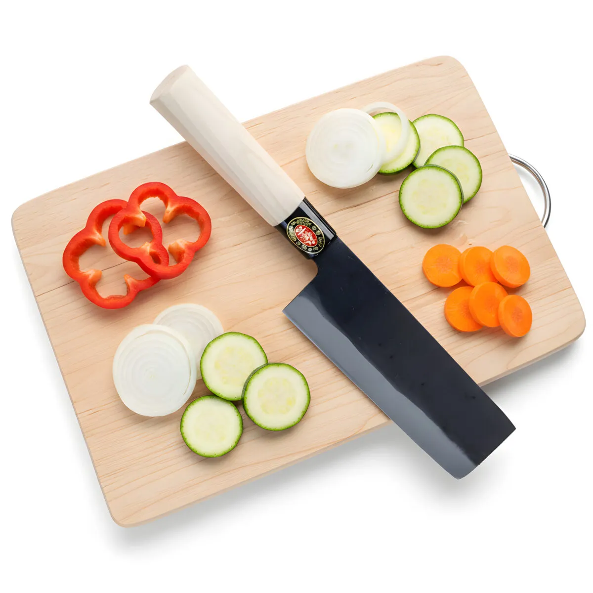 Knife with sliced vegetables on cutting board