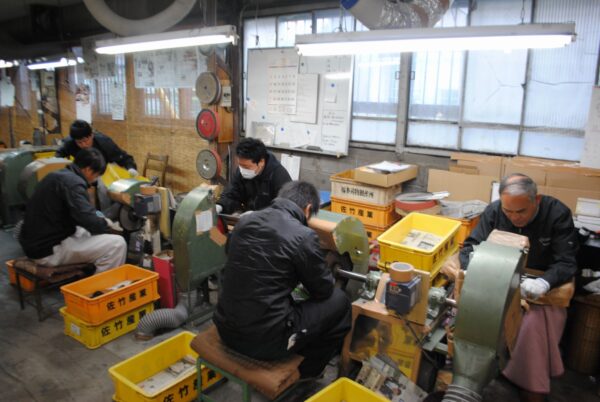 Workers using machines in industrial workshop