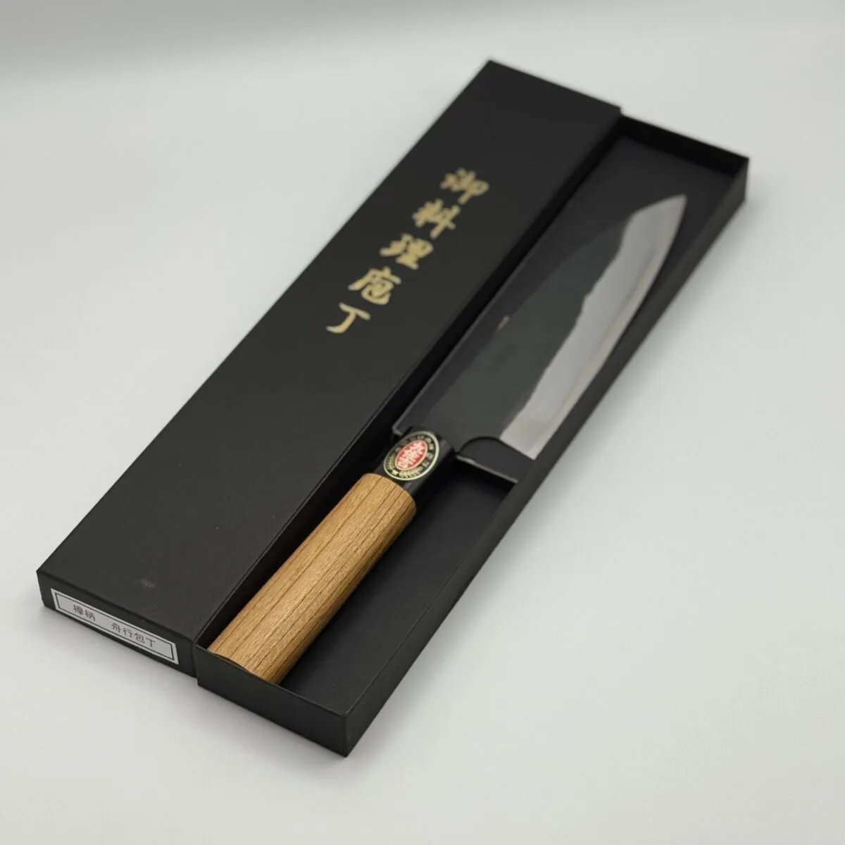Japanese kitchen knife with wooden handle in box.