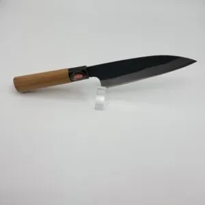 Japanese chef knife with wooden handle on stand.