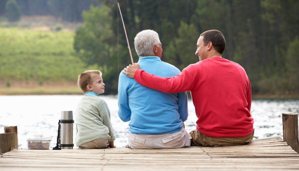Family fishing together on lakeside dock