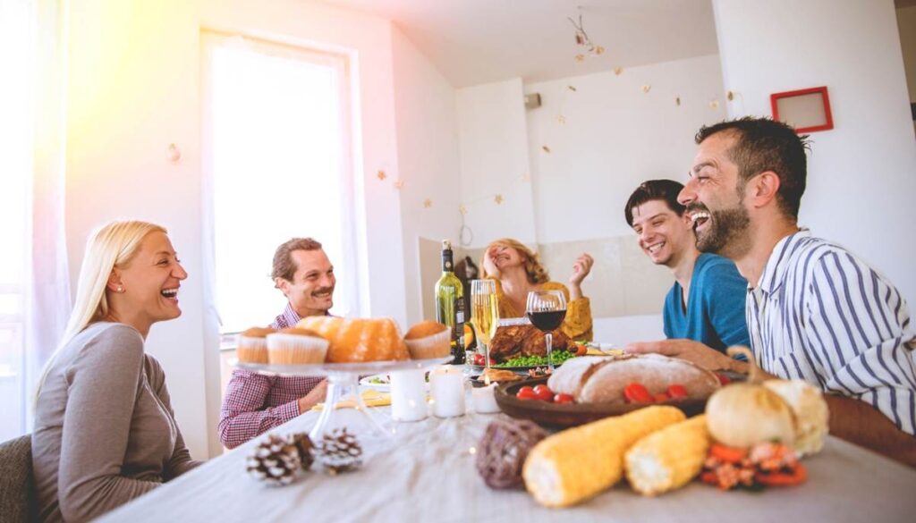 Friends laughing during a festive meal together.