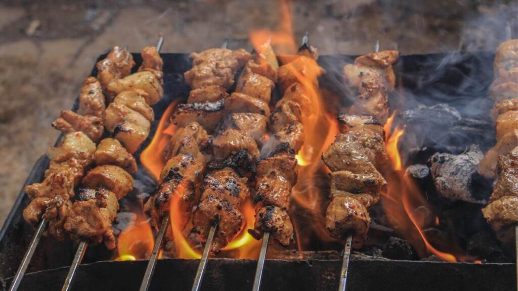 Grilled chicken skewers over open flames