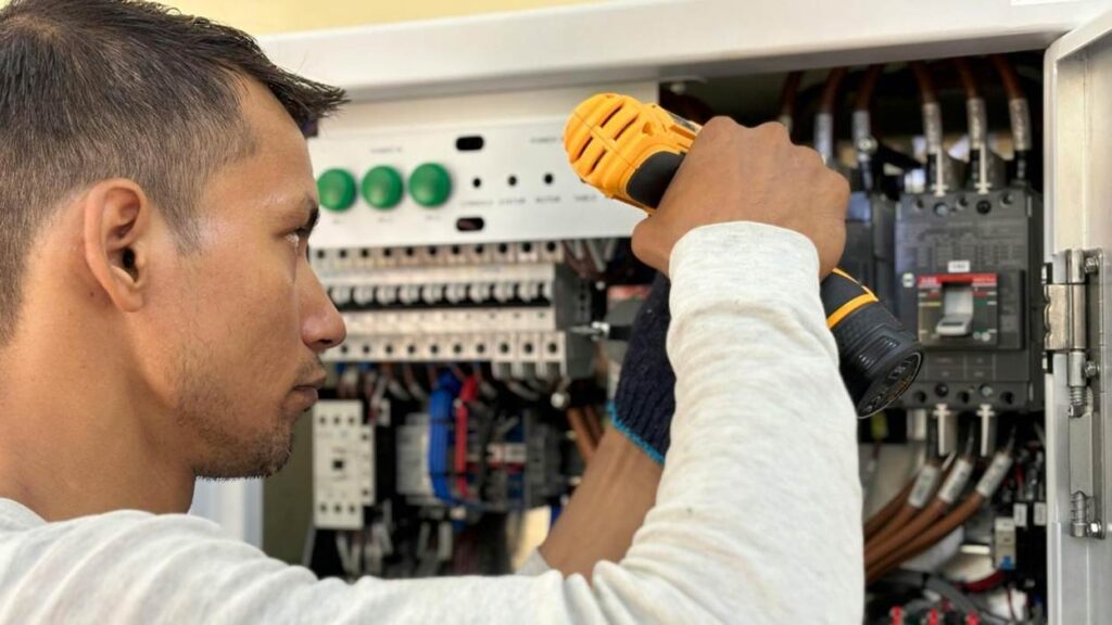 Electrician working on a circuit breaker panel.