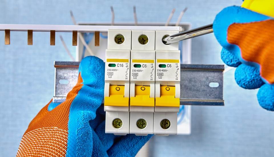 Installing circuit breakers with screwdriver and gloves