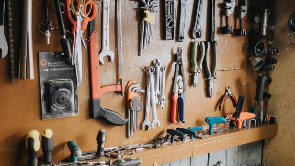 Various tools hanging on a wooden wall.