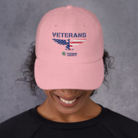 Woman wearing pink Veterans cap with American flag design