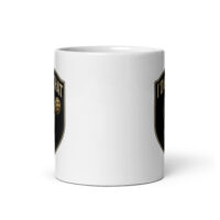White mug with black and gold shield design.