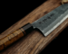 Japanese chef knife on wooden board close-up.