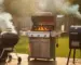 Charcoal kettle, gas grill, and pellet smoker side by side on a backyard deck at golden hour