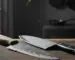 Old chipped chef's knife next to a new shiny chef's knife on a butcher block under dramatic side lighting