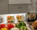 Sunday meal prep scene with roasted chicken, chopped vegetables, and glass meal containers in afternoon light