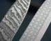 Real Damascus blade with deep layered pattern next to a fake laser-etched blade showing surface differences