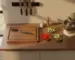 Organized kitchen counter with cutting board, magnetic knife strip, prep bowls, and seasoning in afternoon light