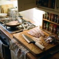 Fish fillets and knife on kitchen cutting board