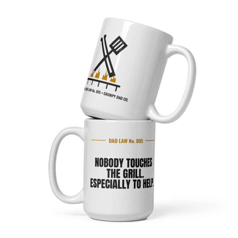 Stacked white dad-themed mugs with grilling slogans